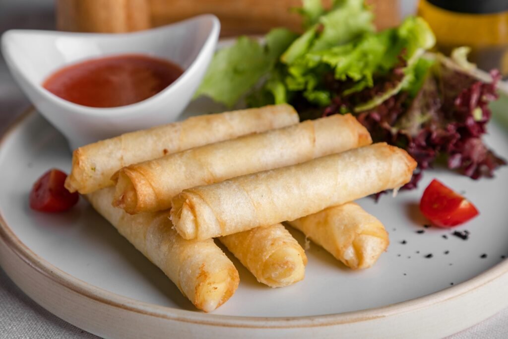 Delicious crispy spring rolls served with a side of fresh lettuce and dipping sauce.